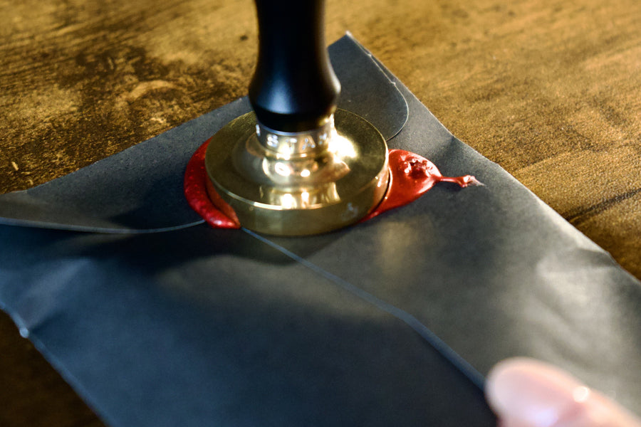 The brass Fallowmark stamp pressed into red wax on a black pouch